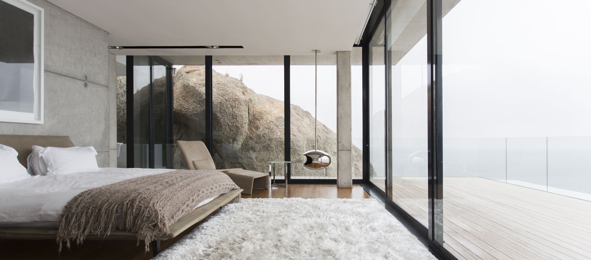 Drzwi narożne i efekt WOW od OknoplusShag rug and glass walls in modern bedroom